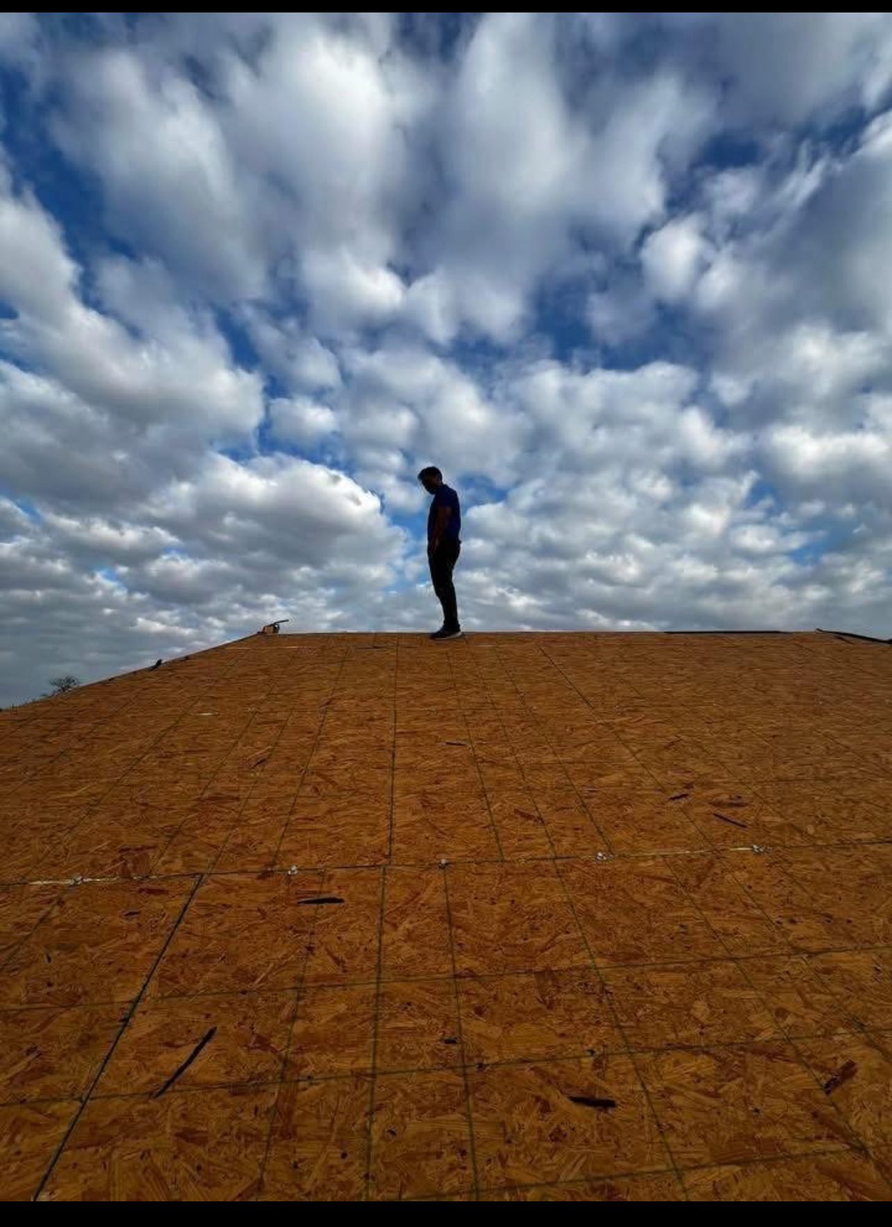 Roofing worker installing OSB decking